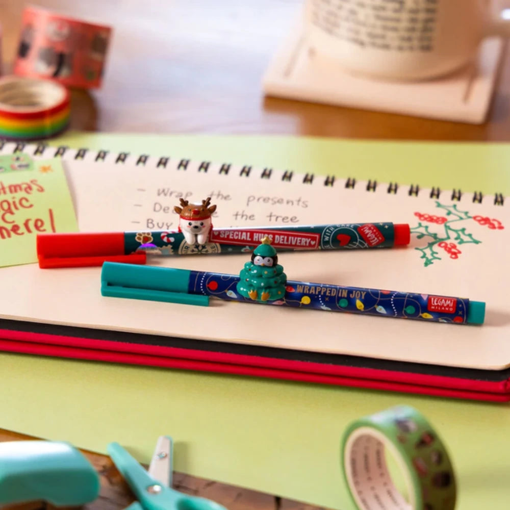 Penna gel Legami Wrapped in Joy con pinguino decorativo ad albero di Natale su un quaderno
